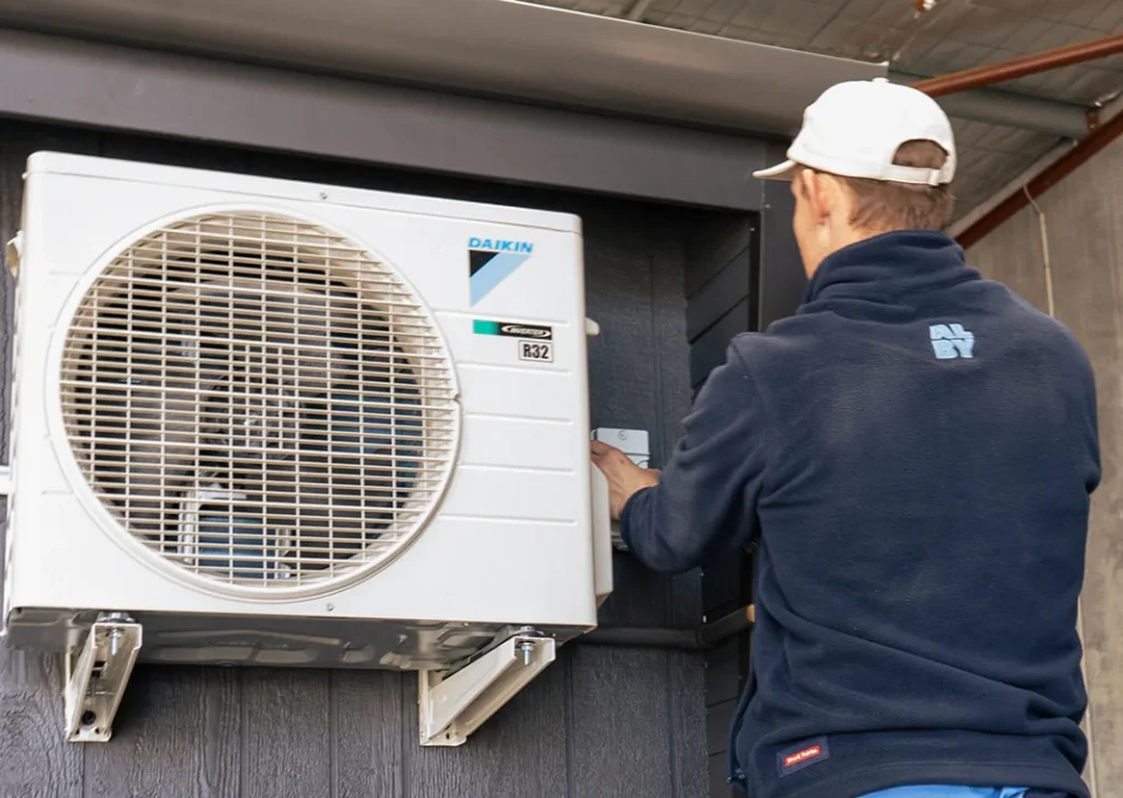 Professional technician installing air conditioning system for Perth’s hot summers.