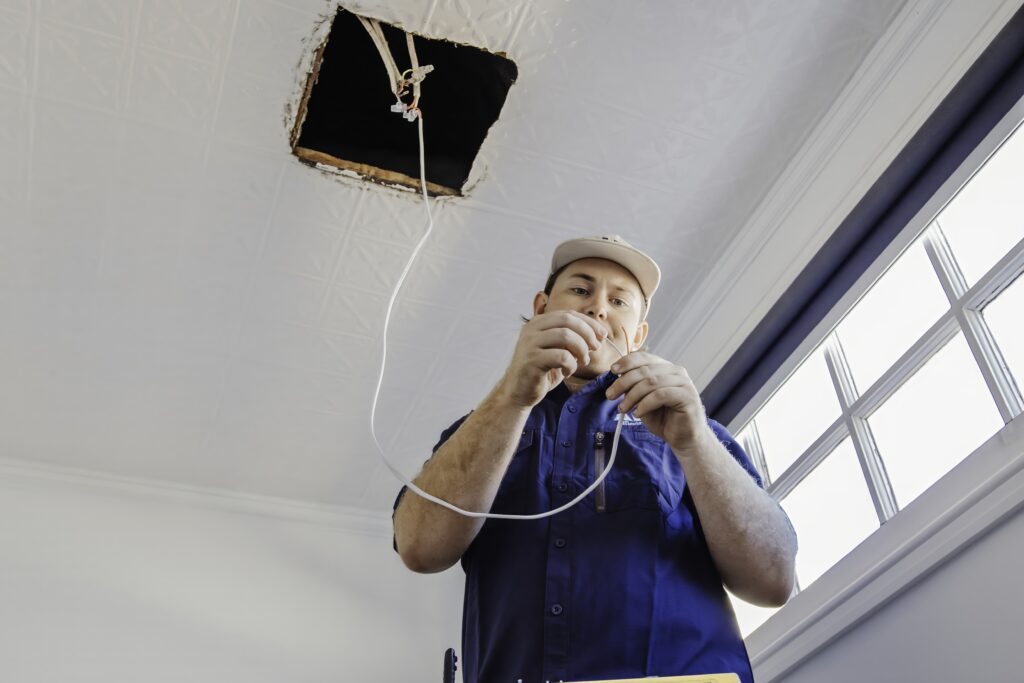 Electrician preparing wiring for emergency lighting installation in Perth.