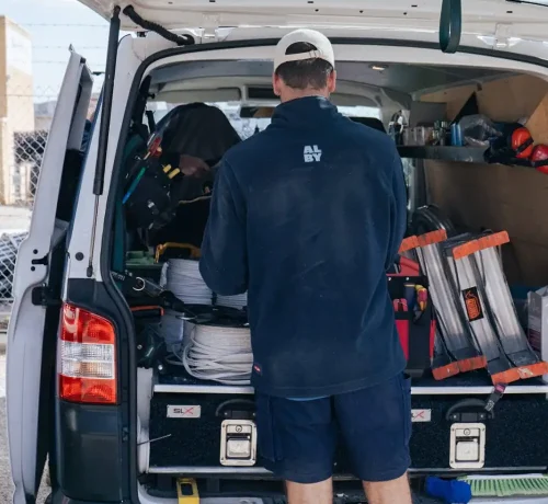 Technician organizing tools in service van for Alby Electrical & Air in Morley, Perth.